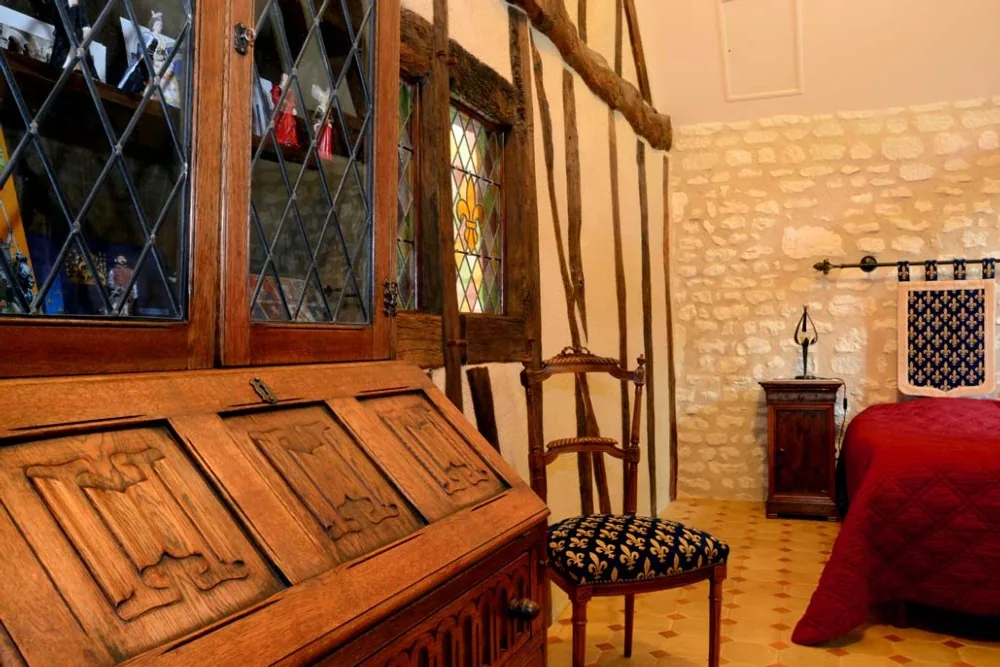 La chambre Médiévale de la Milaudière avec ses antiquités chinés dans la région, comme le secrétaire à plis de serviette.